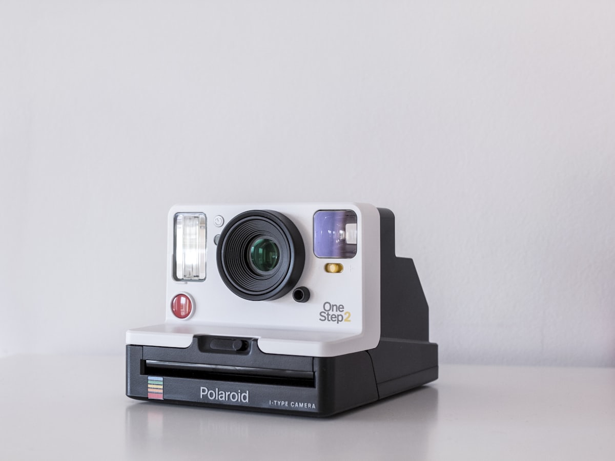 Cámara instantánea sobre una superficie blanca en un estudio fotográfico